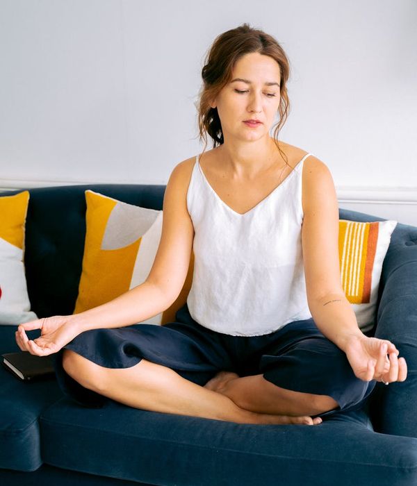 Woman in a calming yoga pose, bathed in soft hydrangea-blue light, symbolizing tranquility.